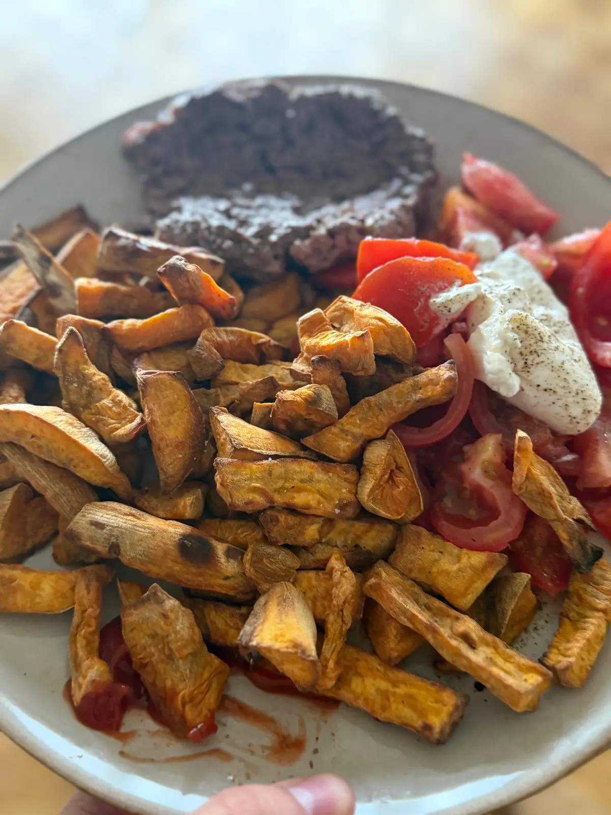 Assiette avec un steak haché, des frites, des tomates et de la mozzarella